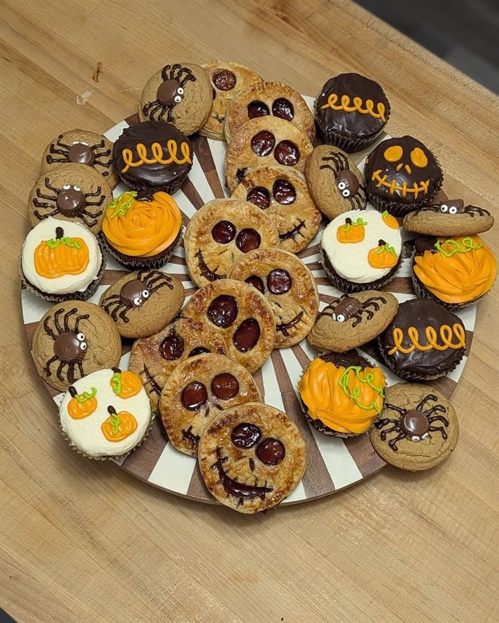 Halloween-themed cookies and cupcakes with pumpkins and spiders