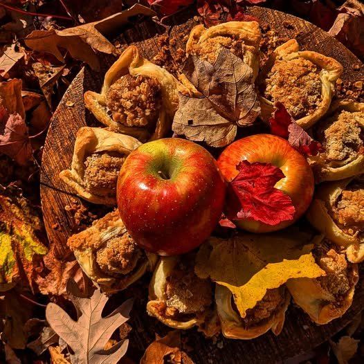 Baked apple desserts with crumble topping among fall leaves