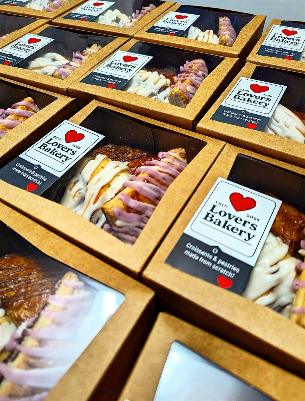 Boxes of assorted croissants and pastries with Lovers Bakery branding